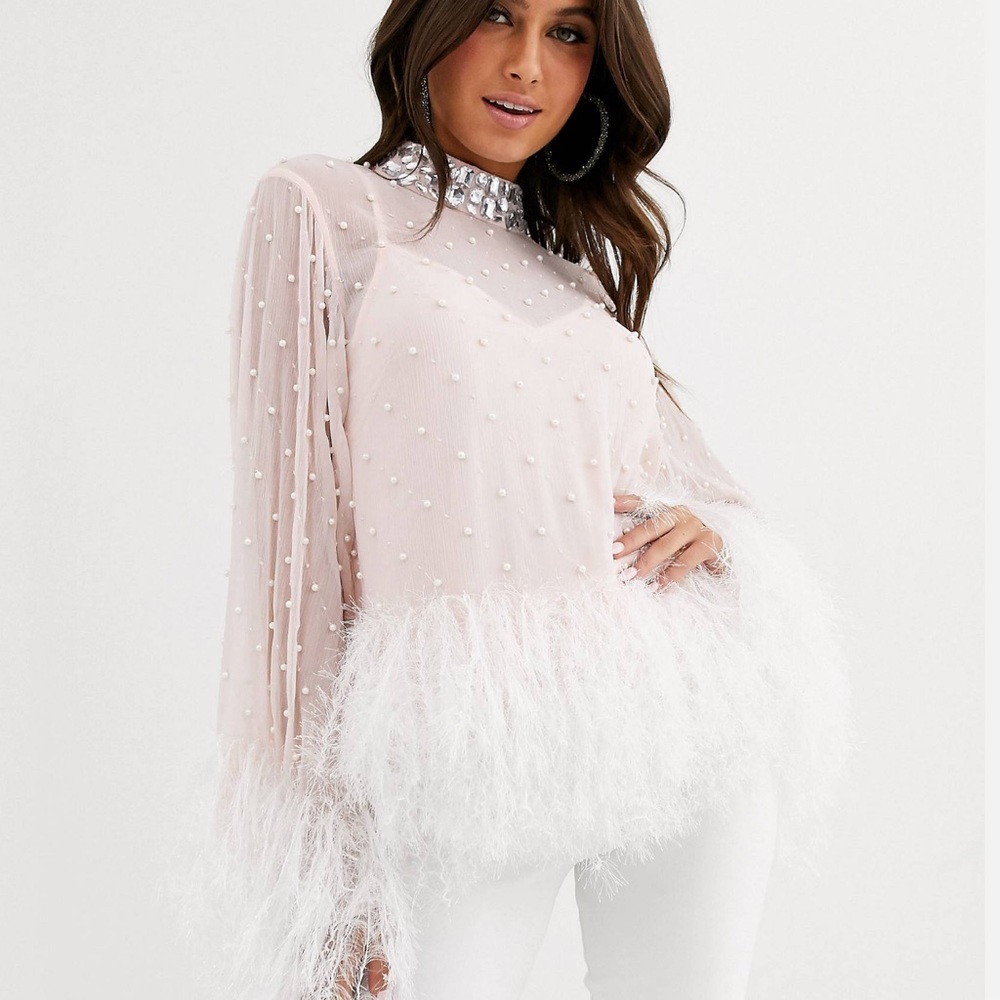 Sheer blouse with pearl embellishment and faux feather hem.